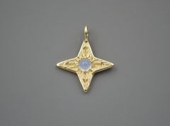 14k yellow gold four pointed compass star with a round blue chalcedony cabochon in the center. 