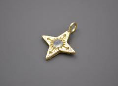 14k yellow gold four pointed compass star with a round blue chalcedony cabochon in the center. Side View.