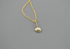 14k gold ladybug pendant on a gold chain on gray background
