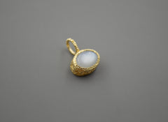 Oval Moonstone set in a textured yellow gold bezel pendant with stars carved into the sides